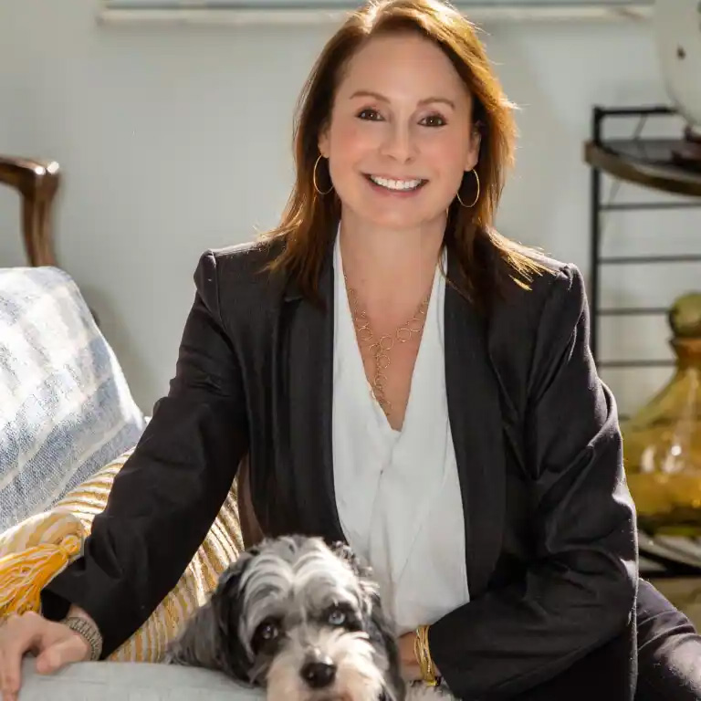 Andrea L. Jakob seated in a welcoming office setting with her dog